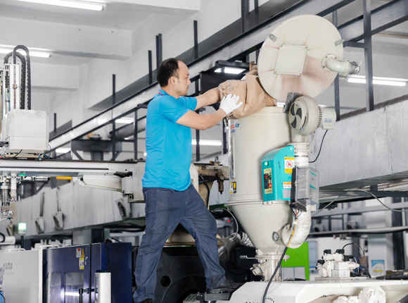 The worker is conducting plastic injection