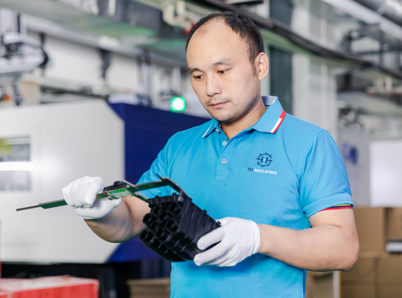 worker examines the specification of plastic parts